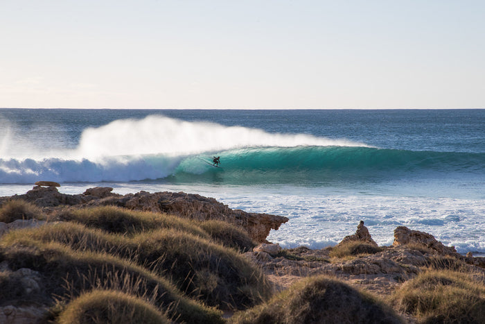 Red Bluff Western Australia, surfer riding wave along rugged coastline, surf photography – Sean Scott Photography