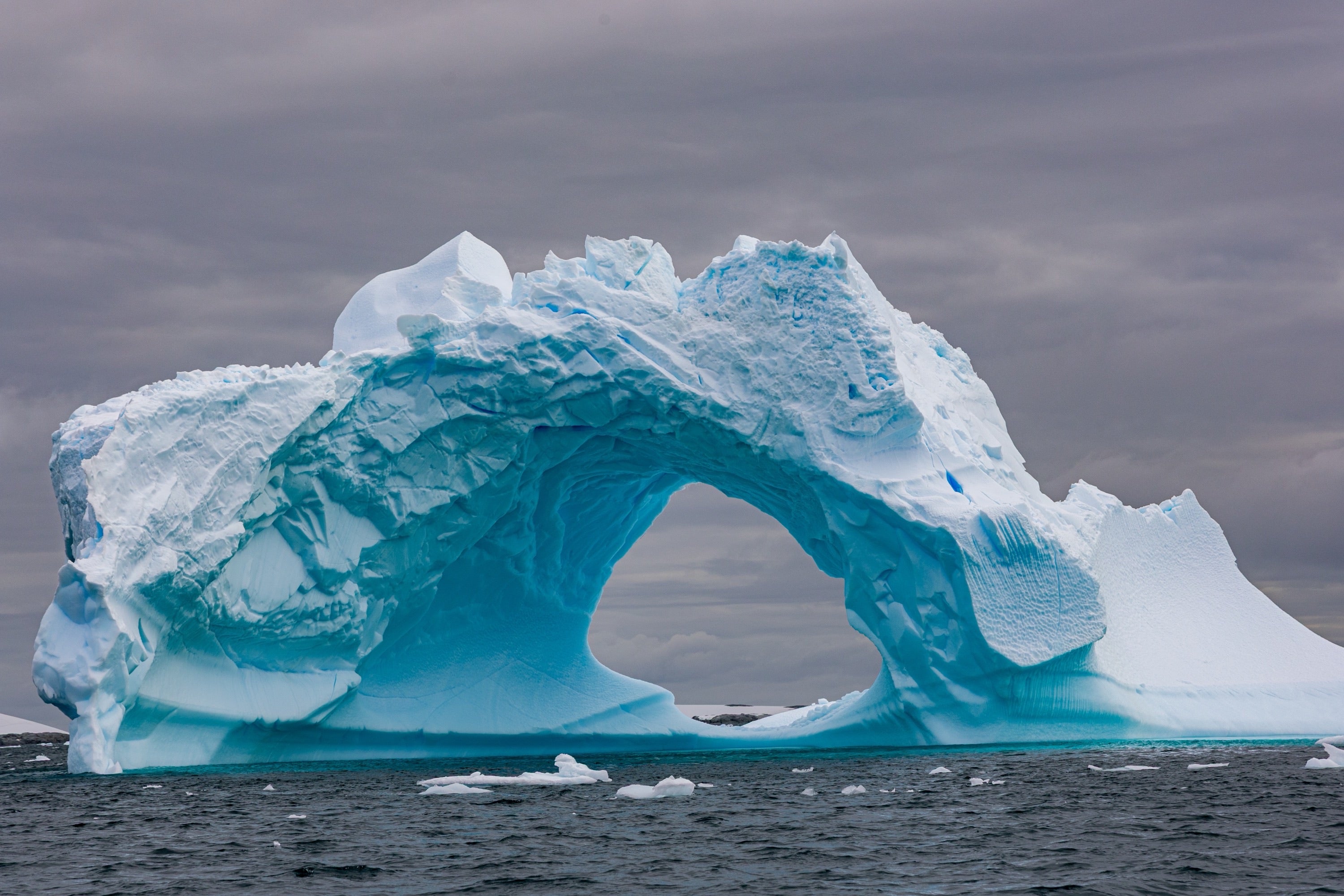 Antarctica, iceberg arch formation with vibrant turquoise water, fine art photography – Sean Scott Photography